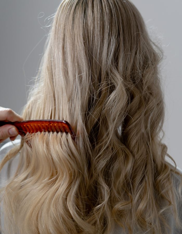 Long blonde hair styled into loose waves
